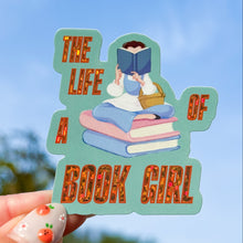Load image into Gallery viewer, Sticker of a girl reading a book with 'The Life of Book Girl' text against a blue sky.