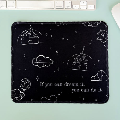 Black mouse pad with white designs and text on a light green surface with a keyboard.