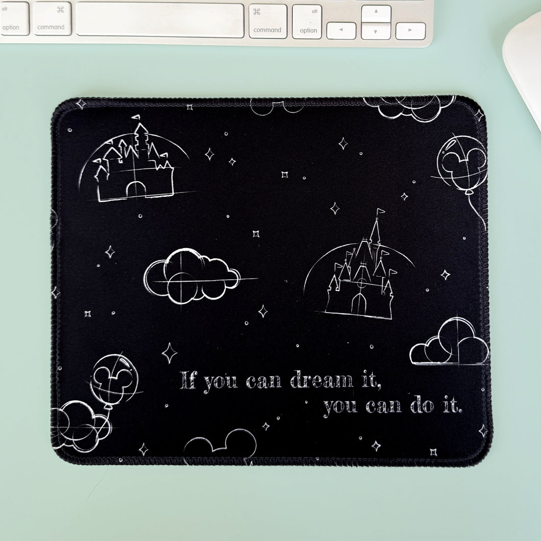 Black mouse pad with white designs and text on a light green surface with a keyboard.