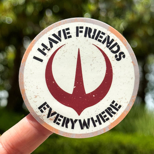 Circular sticker with text 'I have friends everywhere' held by a hand against a blurred green background