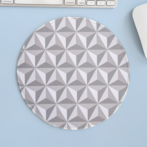Round geometric mouse pad on a light blue surface with a keyboard and mouse.