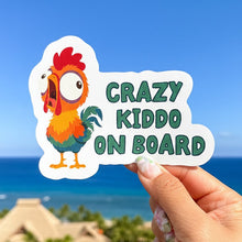 Load image into Gallery viewer, Sticker with a hei hei rooster design and 'Crazy Kiddo on Board' text held against a beach background.
